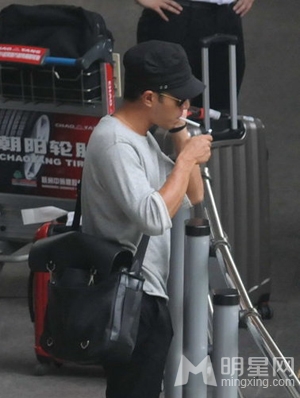 刘恺威黑舌帽现身机场  路边点烟毫无星味
